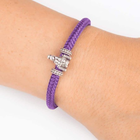 Pulsera de cordón de cabo morado con cierre mosquetón. Con Charm de Virgencita de la Vega. Muestra secundaria en muñeca.