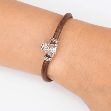Pulsera cuero marrón con cierre mosquetón, con charm de Virgencita del Rocío en plata de Ley. Muestra en muñeca.
