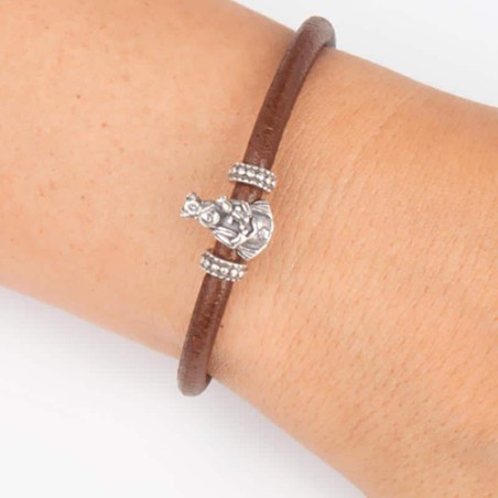 Pulsera de cuero marrón con cierre mosquetón, con charm de Virgen de la Almudena en plata de ley. Muestra en muñeca.