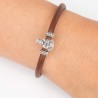 Pulsera de cuero marrón con cierre mosquetón, con charm de Virgen de la Almudena en plata de ley. Muestra en muñeca.