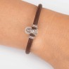 Pulsera de cuero marrón con cierre mosquetón, con charm de Virgencita del Pilar de plata de ley. Muestra en muñeca.