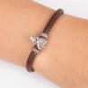 Pulsera de cuero marrón con cierre mosquetón, con charm de Virgencita del Carmen en plata de ley. Muestra en muñeca.
