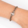 Pulsera de cuero trenzado con cierre mosquetón, con charm de Virgencita de la Milagrosa en plata de ley. Muestra en muñeca.