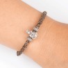 Pulsera de cuero trenzado con cierre mosquetón, con charm de Virgencita de la Almudena en plata de ley. Muestra en muñeca.